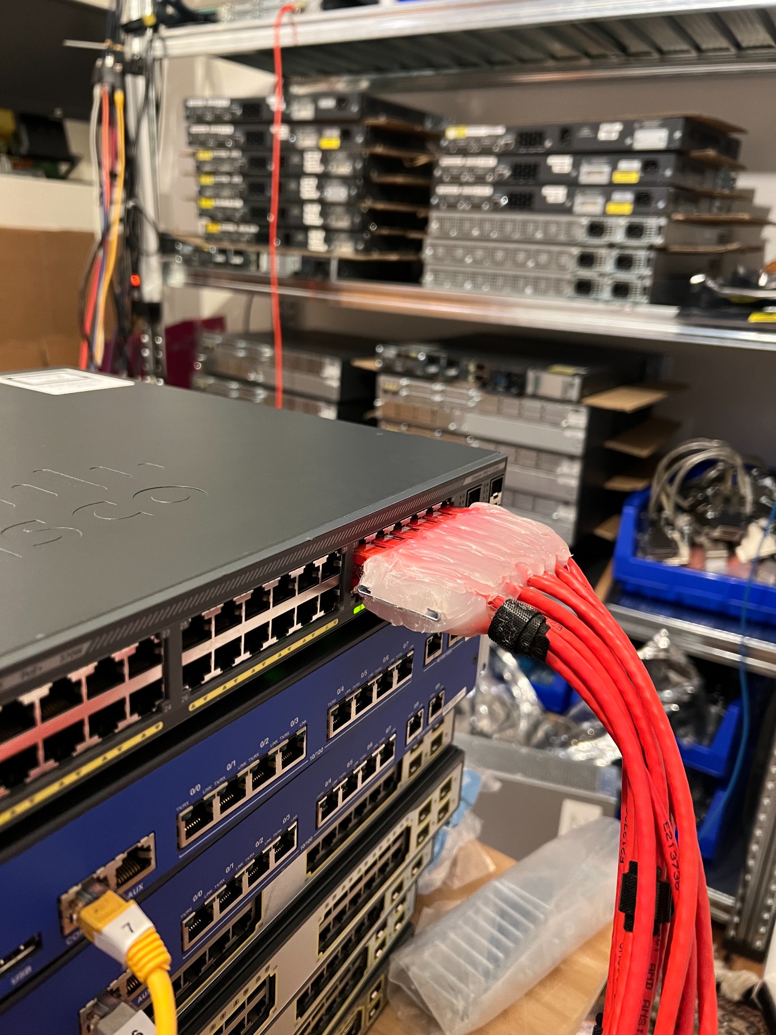 Networking switch setup with multiple red cables connected for automated testing
