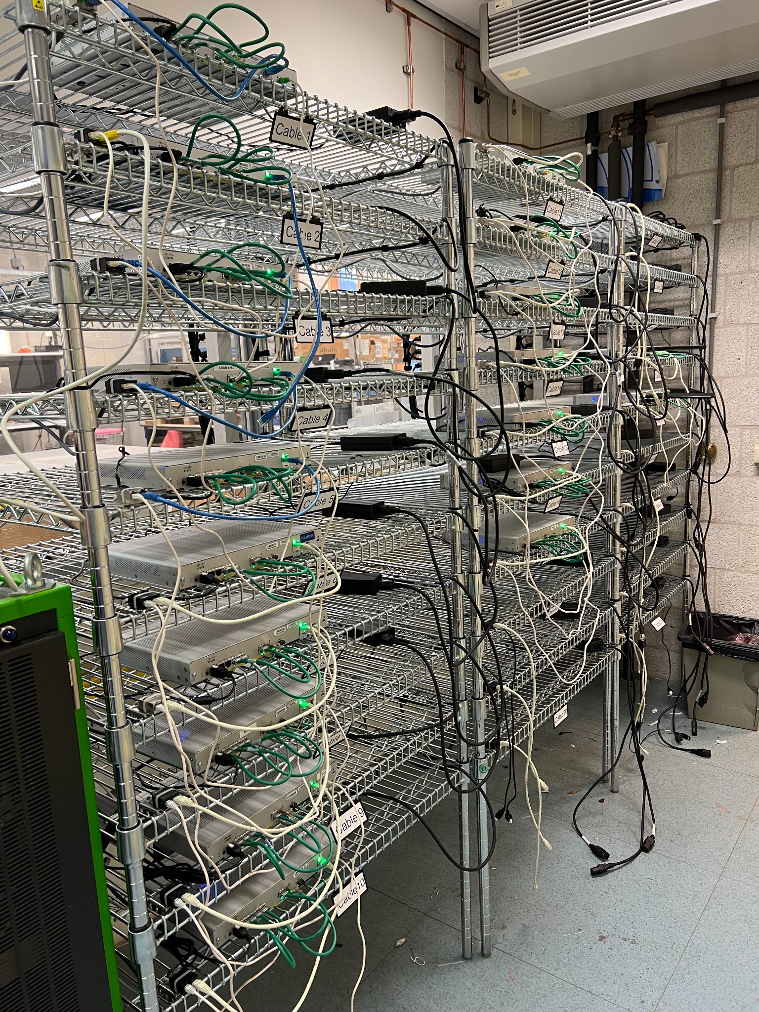 Shelving with many network devices and connected cables in a lab